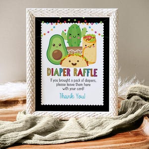 May include: A white frame with a black background and a colorful sign that says "Diaper Raffle". The sign has a cartoon image of a taco, avocado, cactus, and a burrito. The sign says "If you brought a pack of diapers, please leave them here with your card! Thank You!"