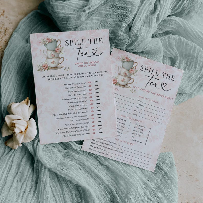 Op de afbeelding: Twee spelkaarten voor een bruidsdouche met de tekst "Spill the Tea" en bloemenillustraties van theekopjes. E&eacute;n kaart is voor de bruid of bruidegom om te raden wie, en de andere vraagt: "Wie kent de bruid het beste?"