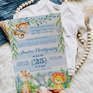 May include: A blue and white baby shower invitation with a jungle theme. The invitation features a monkey, giraffe, elephant, and lion. The text on the invitation reads "We're wild with excitement and happy to say a sweet little baby is on the way!"  "Please join us for a baby shower honoring Amelia Montgomery"  "August 25, 2-4 pm"  "Country Club, 123 Main Street, North Carolina"  "RSVP to Tammy (123) 456-7891"  "Registered at Babies R Us"