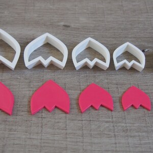 Peut inclure: Ensemble de six emporte-pi&egrave;ces &agrave; fleurs en plastique blanc et six formes de fleurs en p&acirc;te &agrave; sucre rose. Les emporte-pi&egrave;ces sont class&eacute;s par ordre d&eacute;croissant de taille de gauche &agrave; droite. Les formes en p&acirc;te &agrave; sucre sont dans le m&ecirc;me ordre en dessous des emporte-pi&egrave;ces.