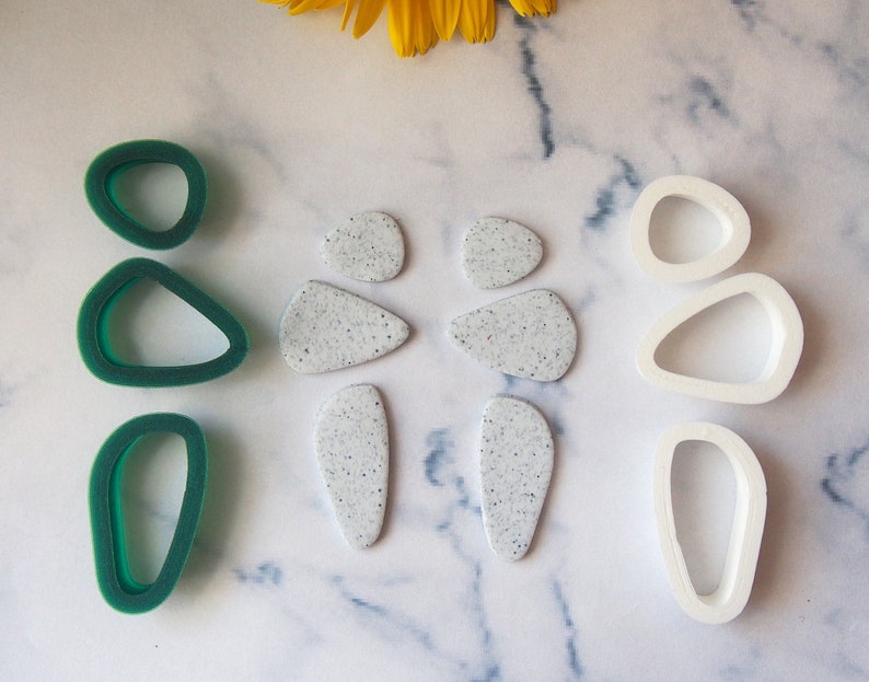 May include: Three sets of polymer clay cutters, one set is green, one set is white, and one set is made of speckled white polymer clay.