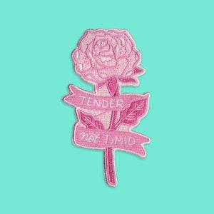 May include: Pink embroidered iron-on patch featuring a rose with the text "Tender not Timid".