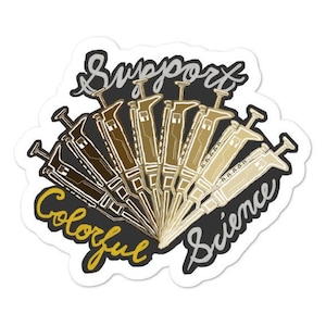 Puede incluir: Una pegatina con un diseño de varias pipetas en forma de abanico, con el texto "Support Colorful Science" escrito a mano.
