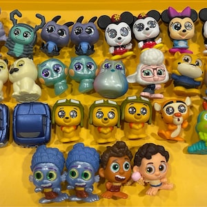 May include: A collection of 24 small, colorful, plastic figurines of popular Disney characters. The characters include Mickey Mouse, Minnie Mouse, Buzz Lightyear, Woody, and more.