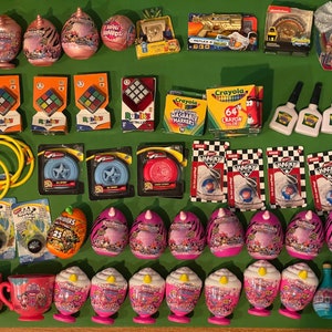 Könnte beinhalten: Eine Auswahl an Spielzeug und Bastelartikeln für Kinder, darunter Rubik's Cubes, Schleim, Fidget Spinner und Einhorn-Spielzeug. Außerdem gibt es Marker, Buntstifte und eine Flasche Zaubertrank.