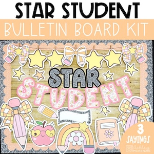 以下が含まれることがあります： 「STAR STUDENT」の文字が大きく書かれた掲示板キット。星とリボンの切り抜き、虹、サングラスをかけたリンゴ、本、鉛筆が含まれています。背景は木目調のパターンです。