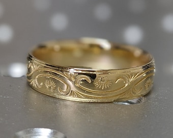 May include: A gold wedding band with an intricate floral design.
