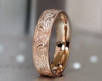 May include: A rose gold wedding band with an intricate floral design.