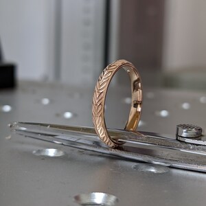 K&ouml;nnte beinhalten: Ein Goldring mit einem eingravierten Blattmotiv.