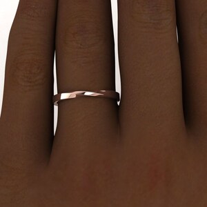 Puede incluir: Un anillo de banda de oro rosa con un dise&ntilde;o retorcido. El anillo se lleva en un dedo.