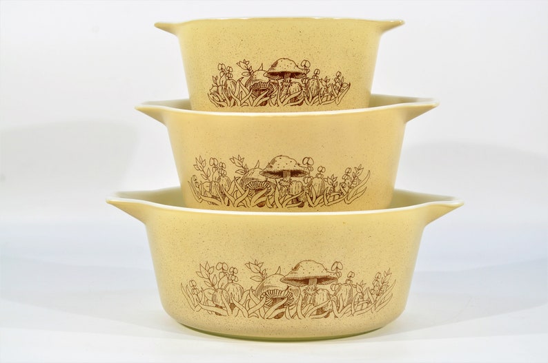 K&ouml;nnte beinhalten: Set aus drei gelben Keramik-Sch&uuml;sseln mit braunem Pilz- und Blumendesign.