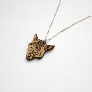 May include: A silver chain necklace with a wooden pendant featuring a detailed laser-engraved image of a wolf's head.