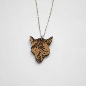 May include: A silver chain necklace with a wooden pendant featuring a detailed laser-engraved fox head.