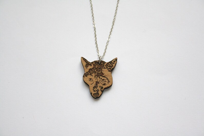 May include: A silver chain necklace with a wooden pendant featuring a detailed laser-engraved fox head.