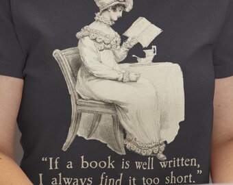 May include: Dark gray t-shirt featuring a vintage illustration of a woman reading a book while seated. The image includes the quote: "If a book is well written, I always find it too short."
