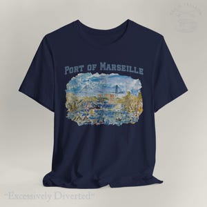 Puede incluir: Camiseta azul marino con una pintura de acuarela del puerto de Marsella. El texto "Port of Marseille" est&aacute; encima de la imagen. La camiseta tambi&eacute;n tiene el texto "Excessively Diverted" en la parte inferior.