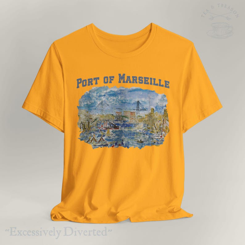 Puede incluir: Camiseta de color amarillo mostaza con una ilustraci&oacute;n azul del puerto de Marsella y el texto "PORT OF MARSEILLE". La camiseta tambi&eacute;n tiene el texto "Excessively Diverted" en la parte inferior.