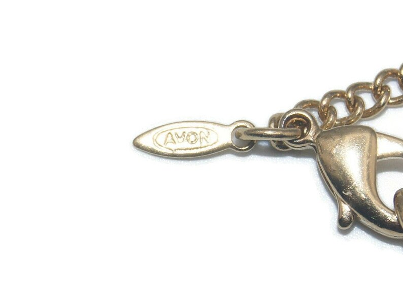 May include: Gold-toned chain necklace with a lobster clasp fastening. The tag on the necklace reads "AVON".