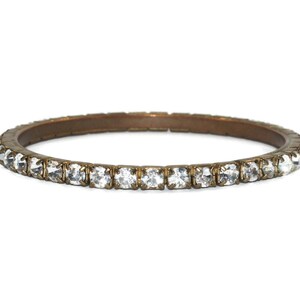 May include: A gold-toned bangle bracelet with a row of clear rhinestones around the edge.