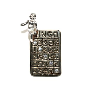 Cartão de bingo vintage dourado e prateado e strass com alfinete de lapela de querubim. Pin de boa sorte em dois tons.