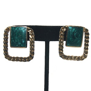 May include: A pair of gold tone earrings with a square green enamel design. The earrings have a chain link design around the edge.