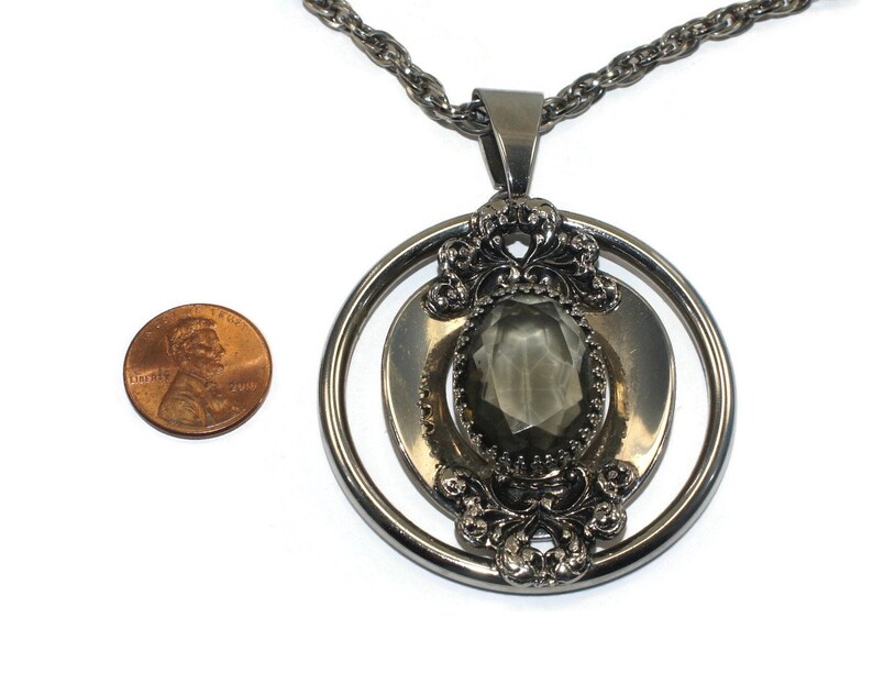 Vintage Southwestern Style Round Silver Tone Pendant with Faceted Faux Smoky Topaz on 24 Inch Silver Tone Chain with Spring Ring Clasp.