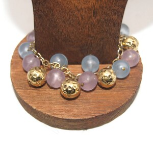 Tono dorado vintage con cuentas de plástico en tono morado, azul y dorado. Pulsera de 8 pulgadas con cierre de pinza de langosta.