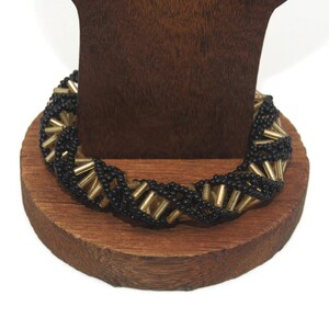 Pulsera vintage trenzada de 7 pulgadas con cuentas de plástico en tono negro y dorado con cierre magnético de bronce.