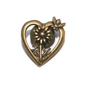 Puede incluir: Pin de corazón dorado con un diseño detallado de flor y abeja.