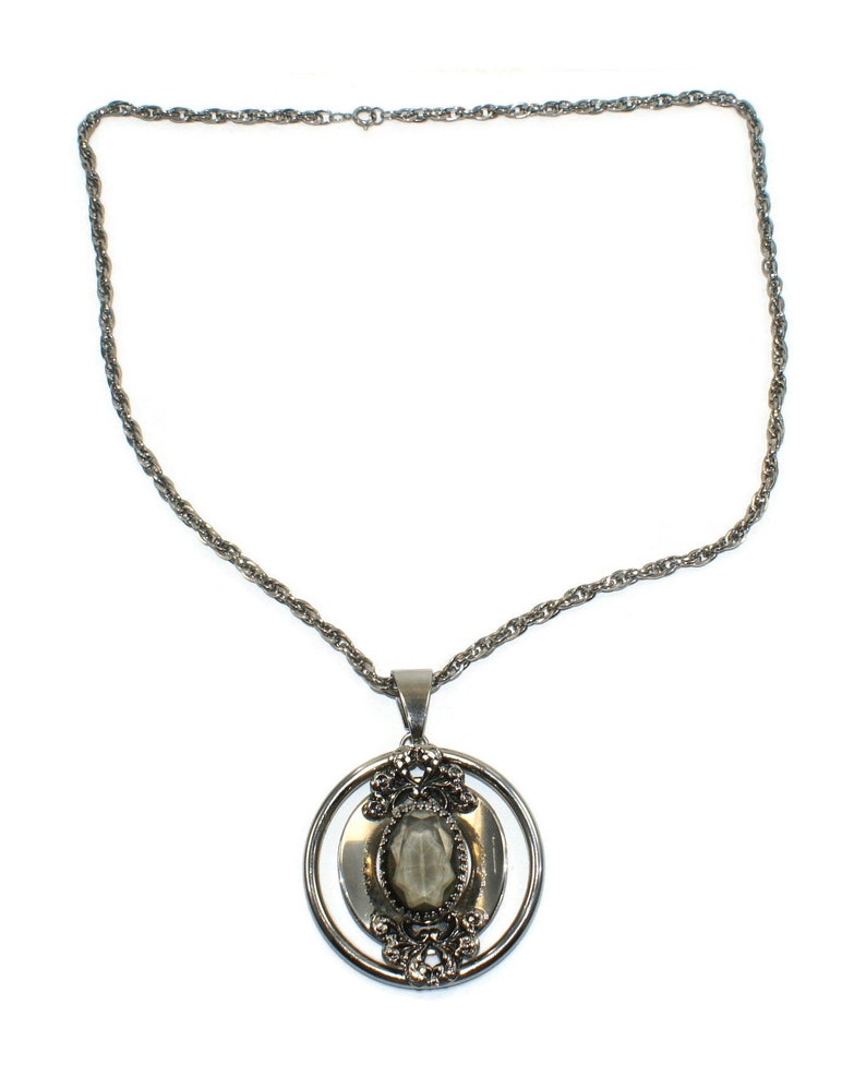 Vintage Southwestern Style Round Silver Tone Pendant with Faceted Faux Smoky Topaz on 24 Inch Silver Tone Chain with Spring Ring Clasp.