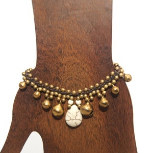 Cuentas y campanas en tono dorado vintage y pulsera de 7 pulgadas con cuentas de howlita en cordón marrón con cierre de botón.