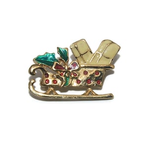Vintage gouden toon met witte, groene en rode emaille kerstslee met cadeautjesbroche.