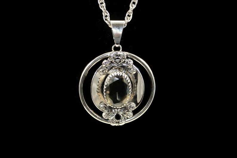 Vintage Southwestern Style Round Silver Tone Pendant with Faceted Faux Smoky Topaz on 24 Inch Silver Tone Chain with Spring Ring Clasp.