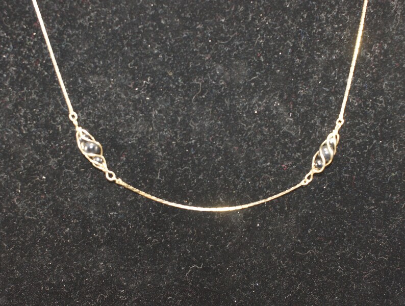 Vintage Gold Tone and Caged Black Beads 24 Inch Necklace with Spring Ring Clasp.