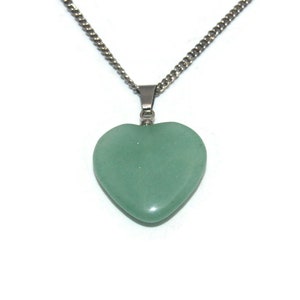 May include: A silver chain necklace with a green heart-shaped pendant.