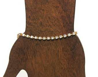 Vintage Gold Tone and Clear Rhinestones 7 1/2 Inch Tennis Bracelet with Spring Ring Clasp.