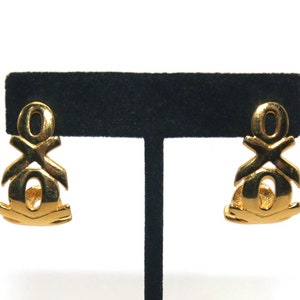 May include: A pair of gold-tone clip-on earrings featuring an interlocking XO design.