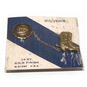 Tono d'oro vintage e smalto nero Tulsa Okla Monkey Island Mahawk Park Souvenir Pin con stivali da cowboy su carta originale.