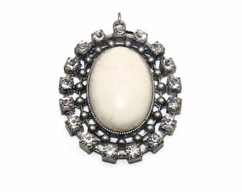 Ton argent vintage, strass clairs et pendentif ovale en verre blanc.