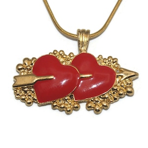 Colgante de 2 corazones perforados en tono dorado vintage y esmalte rojo en cadena de tono dorado de 18 pulgadas con cierre de pinza de langosta.