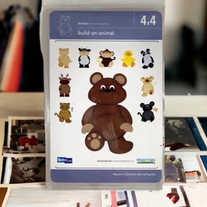 May include: A set of 4x4 inch die-cut shapes for crafting. The set includes a bear, a cow, a monkey, a duck, a panda, a reindeer, a cat, and a mouse. The set is labeled "build-an-animal" and includes two cutting dies. It requires a Quickutz die-cutting tool.