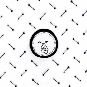 May include: Black and white embroidered patch featuring a cartoon face and the text "oh god no". The patch is surrounded by a black circle and is on a white background with black arrows.