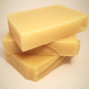 May include: Three bars of pale yellow soap stacked on top of each other.