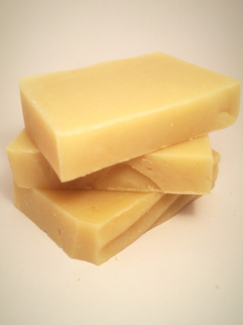 May include: Three bars of pale yellow soap stacked on top of each other.