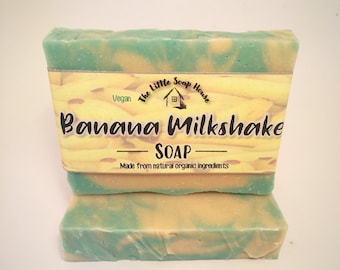 May include: Two bars of Banana Milkshake soap. The soap has a light green and yellow swirl pattern. The soap is wrapped with a label that reads "Banana Milkshake Soap" and "Made from natural organic ingredients."