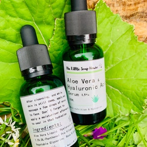 Puede incluir: Dos botellas de vidrio verde con goteros negros que contienen suero de aloe vera y &aacute;cido hialur&oacute;nico al 1,5%. Las botellas est&aacute;n etiquetadas con el nombre del producto y los ingredientes. Las botellas est&aacute;n sobre una hoja verde.
