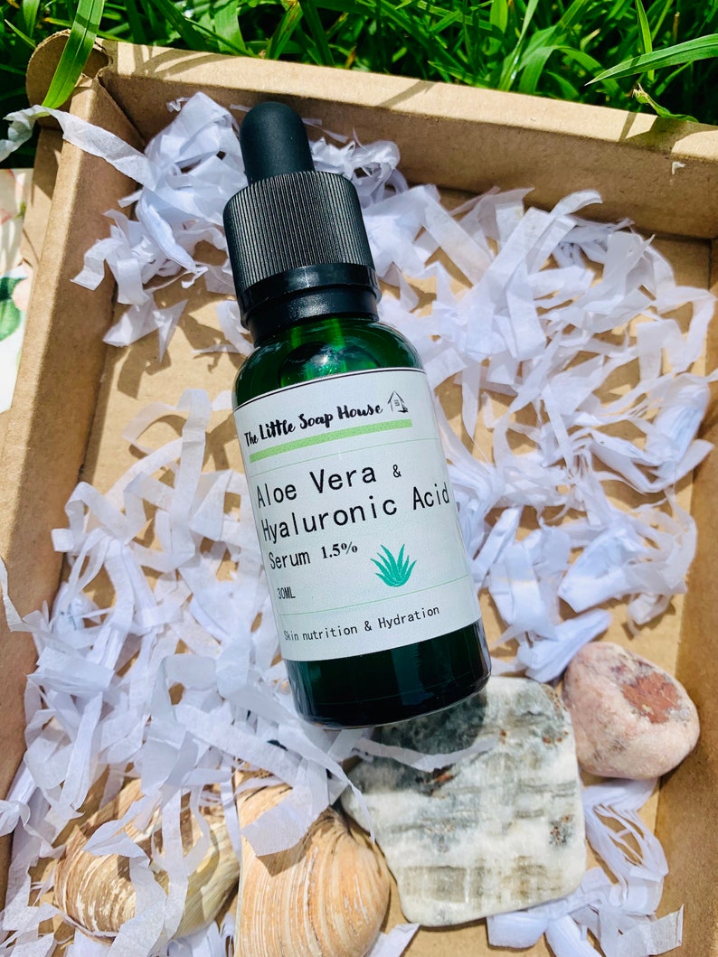 Puede incluir: Una botella de vidrio verde con un gotero negro, etiquetada "The Little Soap House Aloe Vera & Hyaluronic Acid Serum 1.5% 30ML Skin nutrition & Hydration".