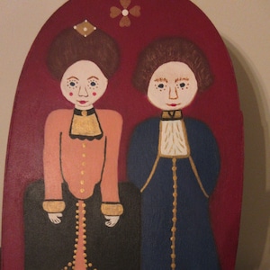 May include: A hand-painted wooden oval with a red background. Two figures are painted on the oval. The figure on the left is a woman wearing a pink dress with a black jacket and gold trim. The figure on the right is a man wearing a blue jacket with gold trim and black pants. Both figures have white skin and brown hair.