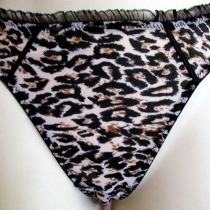 Calcinha fio dental com babados em organza preta com estampa animal. L - XL