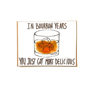 K&ouml;nnte beinhalten: Eine Gru&szlig;karte mit einer Zeichnung eines Glases Bourbon mit Eisw&uuml;rfeln. Der Text auf der Karte lautet "In Bourbon-Jahren bist du einfach leckerer geworden."